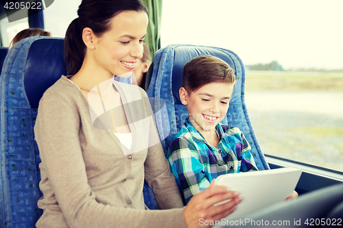 Image of happy family with tablet pc sitting in travel bus