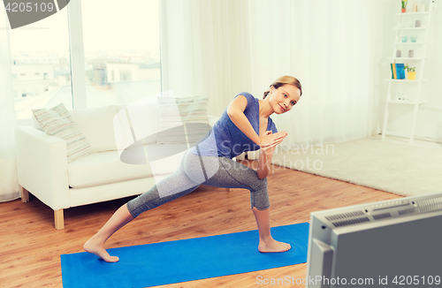 Image of woman making yoga low angle lunge pose on mat