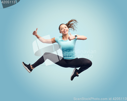 Image of happy smiling sporty young woman jumping in air