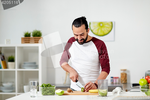 Image of man with blender and fruit cooking at home kitchen