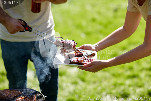 Image of man cooking meat at summer party barbecue