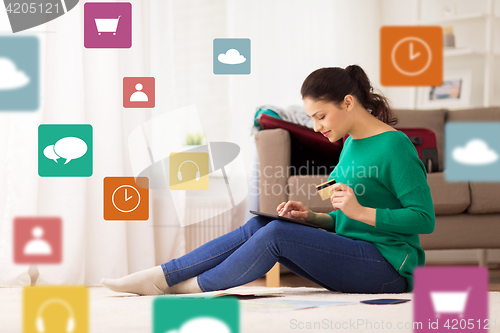 Image of woman with tablet pc and credit card at home