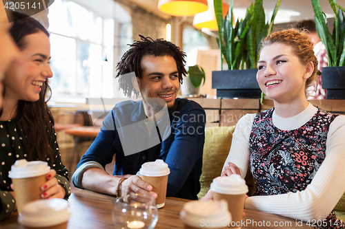 Image of happy friends drinking coffee at restaurant