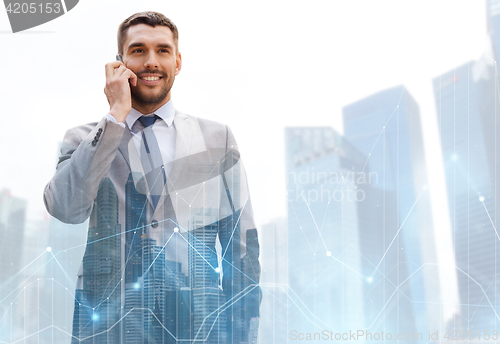 Image of happy businessman calling on smartphone in city