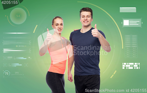 Image of happy sportive man and woman showing thumbs up