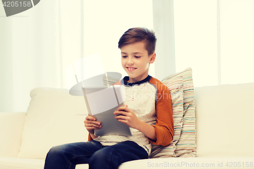 Image of smiling boy with tablet computer at home