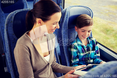 Image of happy family with tablet pc sitting in travel bus