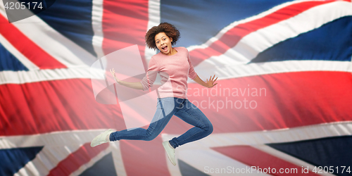 Image of african american woman jumping over english flag