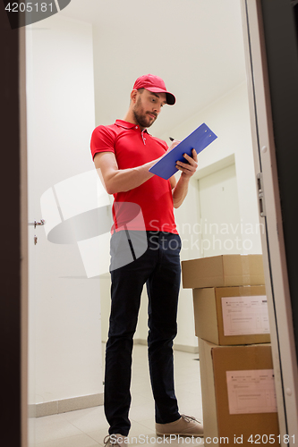 Image of delivery man with boxes and clipboard at door