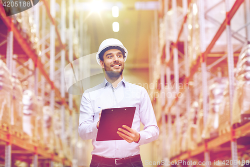 Image of happy businessman with clipboard at warehouse