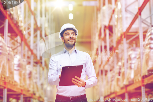 Image of happy businessman with clipboard at warehouse