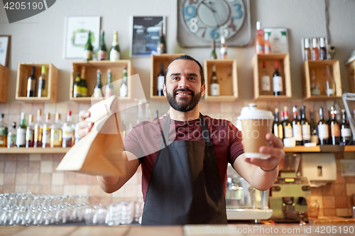 Image of man or waiter with coffee and paper bag at bar