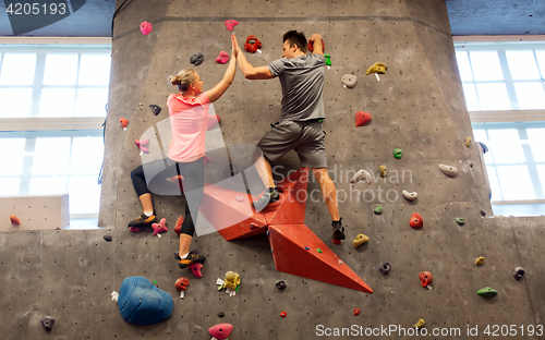 Image of man and woman exercising at indoor climbing gym