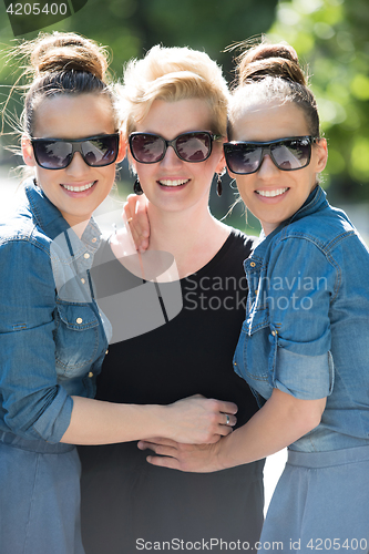 Image of portrait of three young beautiful woman with sunglasses