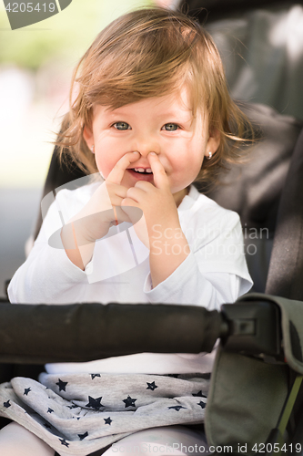 Image of baby girl sitting in the pram