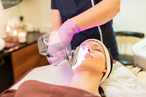 Image of young woman having face microdermabrasion at spa