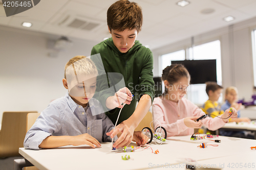 Image of happy children building robots at robotics school