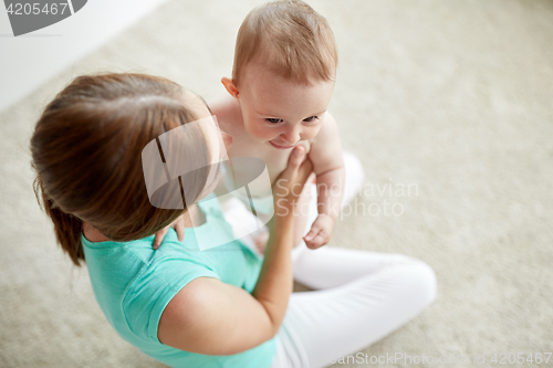 Image of happy young mother with little baby at home