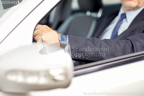 Image of senior businessman hands driving car