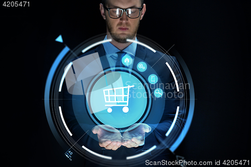 Image of businessman with virtual shopping cart projection