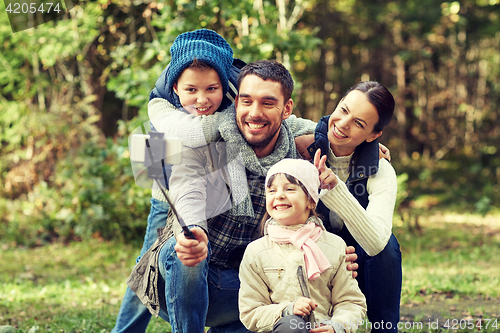 Image of happy family with smartphone selfie stick in woods