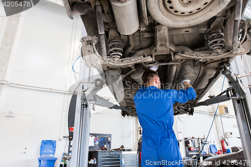 Image of mechanic man or smith repairing car at workshop