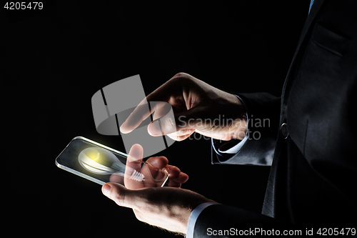 Image of businessman with lightbulb on smartphone