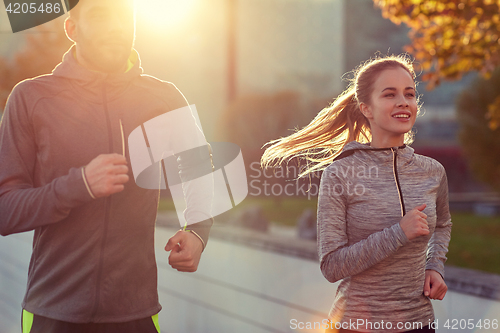 Image of happy couple running outdoors