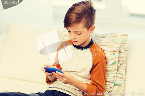 Image of boy with smartphone texting or playing at home