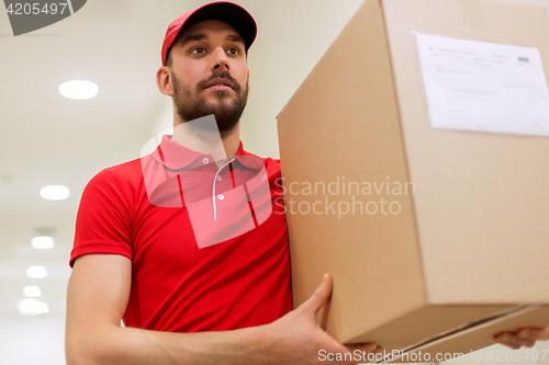 Image of delivery man with parcel box in corridor