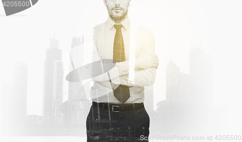 Image of businessman with crossed arms over city buildings