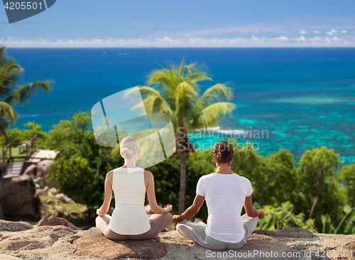 Image of smiling couple making yoga exercises outdoors