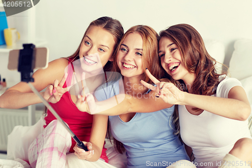 Image of teen girls with smartphone taking selfie at home