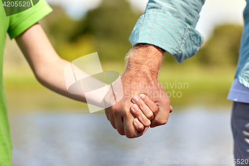 Image of senior man and child holding hands