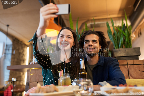 Image of happy couple taking selfie at cafe or bar