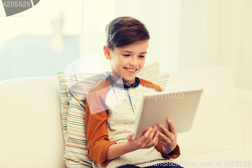 Image of smiling boy with tablet computer at home