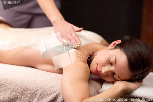 Image of woman lying and having back massage at spa