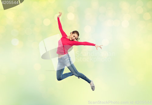 Image of happy young woman jumping in air or dancing