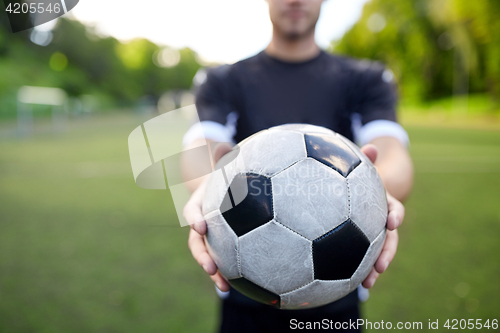 Image of soccer player with ball on football field