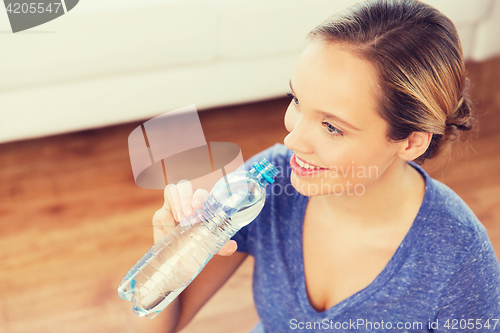 Image of happy woman with water bottle at home