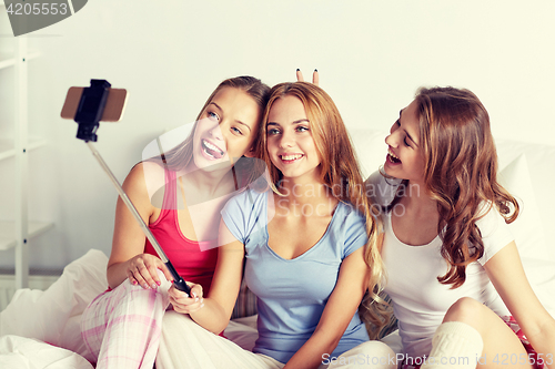 Image of teen girls with smartphone taking selfie at home