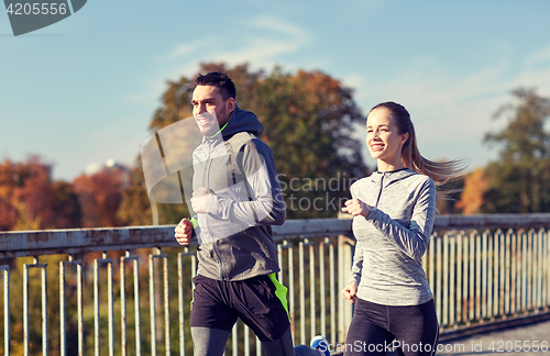 Image of happy couple running outdoors