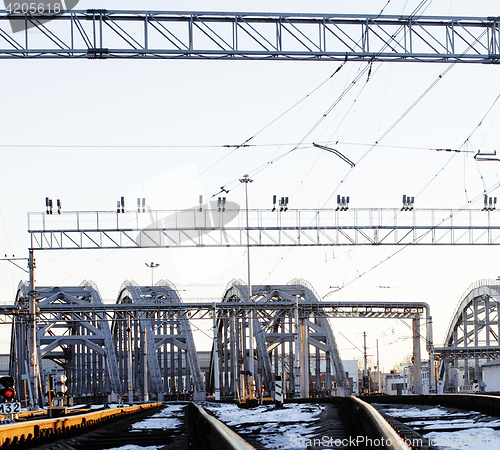 Image of landscape with railway with trains, lot of steel rafters at sunset 