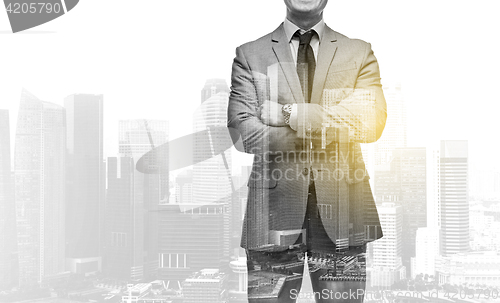 Image of businessman with crossed arms over city buildings