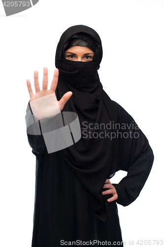 Image of muslim woman in hijab showing stop sign