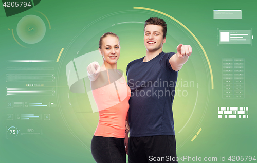 Image of happy sportive man and woman pointing finger