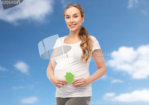 Image of happy pregnant woman with green house