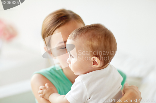 Image of happy young mother with little baby at home