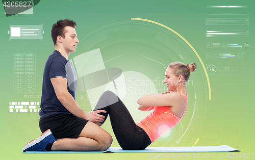 Image of happy sportive man and woman doing sit-ups