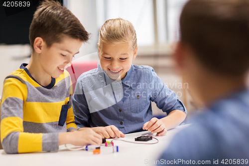 Image of happy children building robots at robotics school